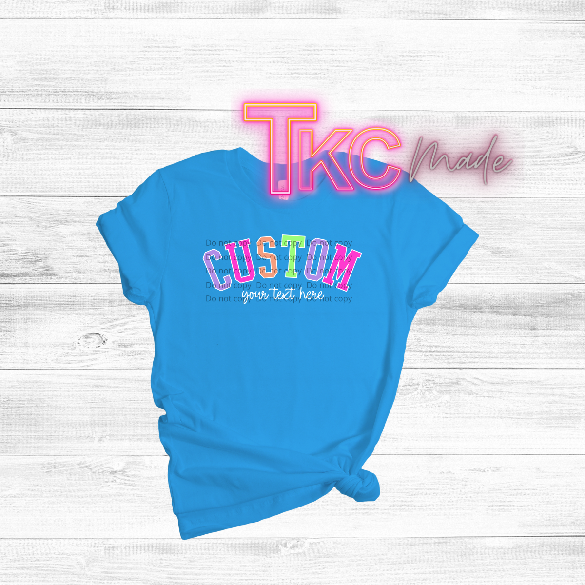 Blue t-shirt with customizable text on a white wooden background