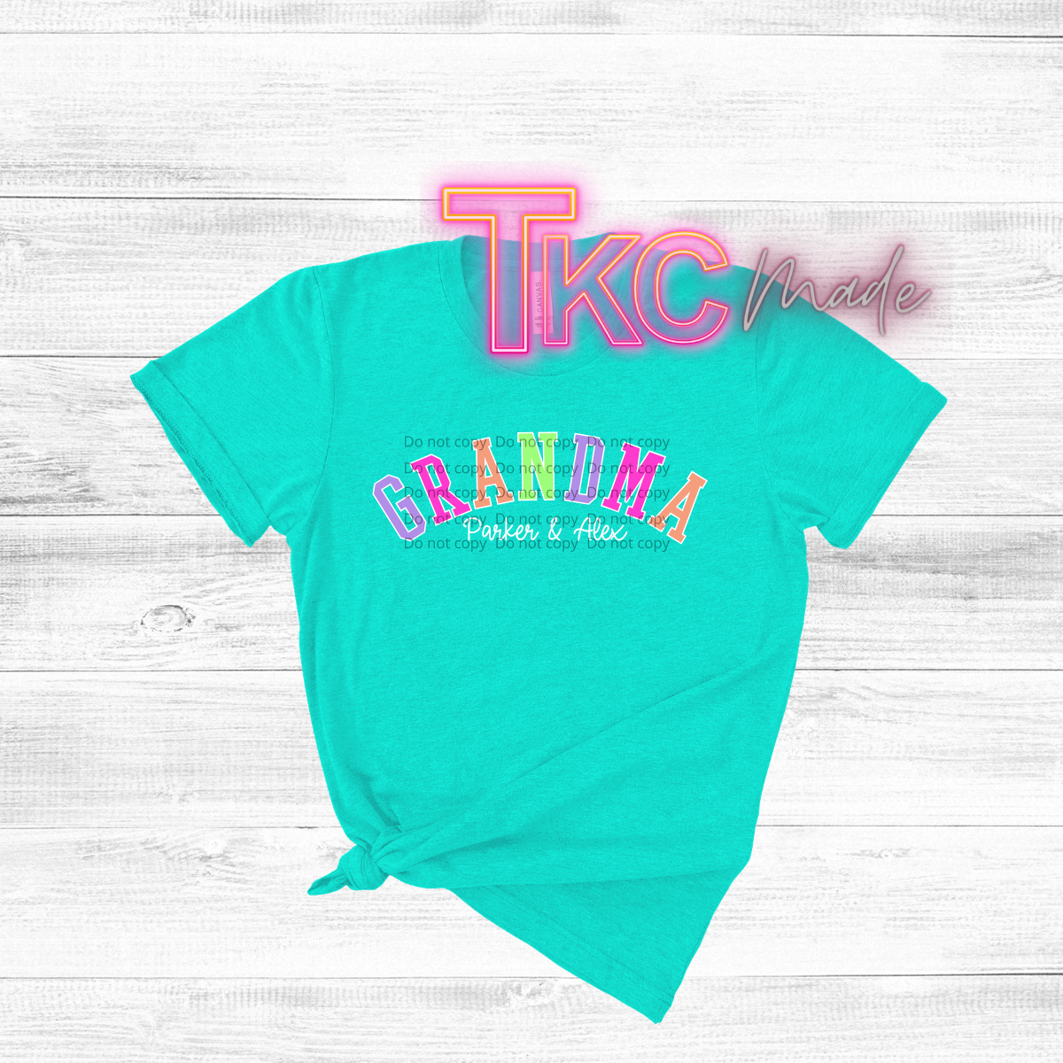 Turquoise t-shirt with colorful text grandma and 2 kids names on a light wooden surface