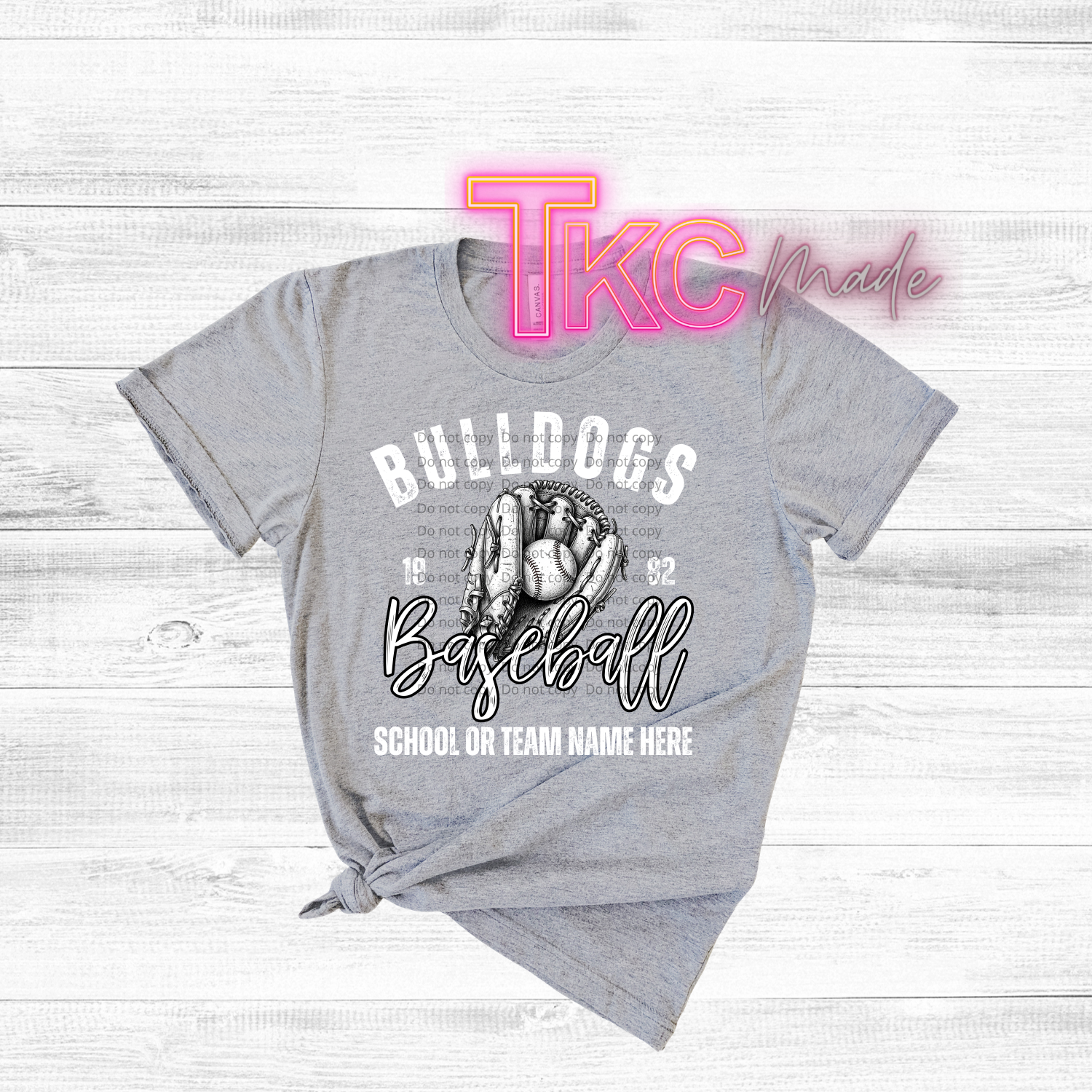 Gray t-shirt with baseball graphic and text on a wooden surface, featuring 'TKC made' branding.
