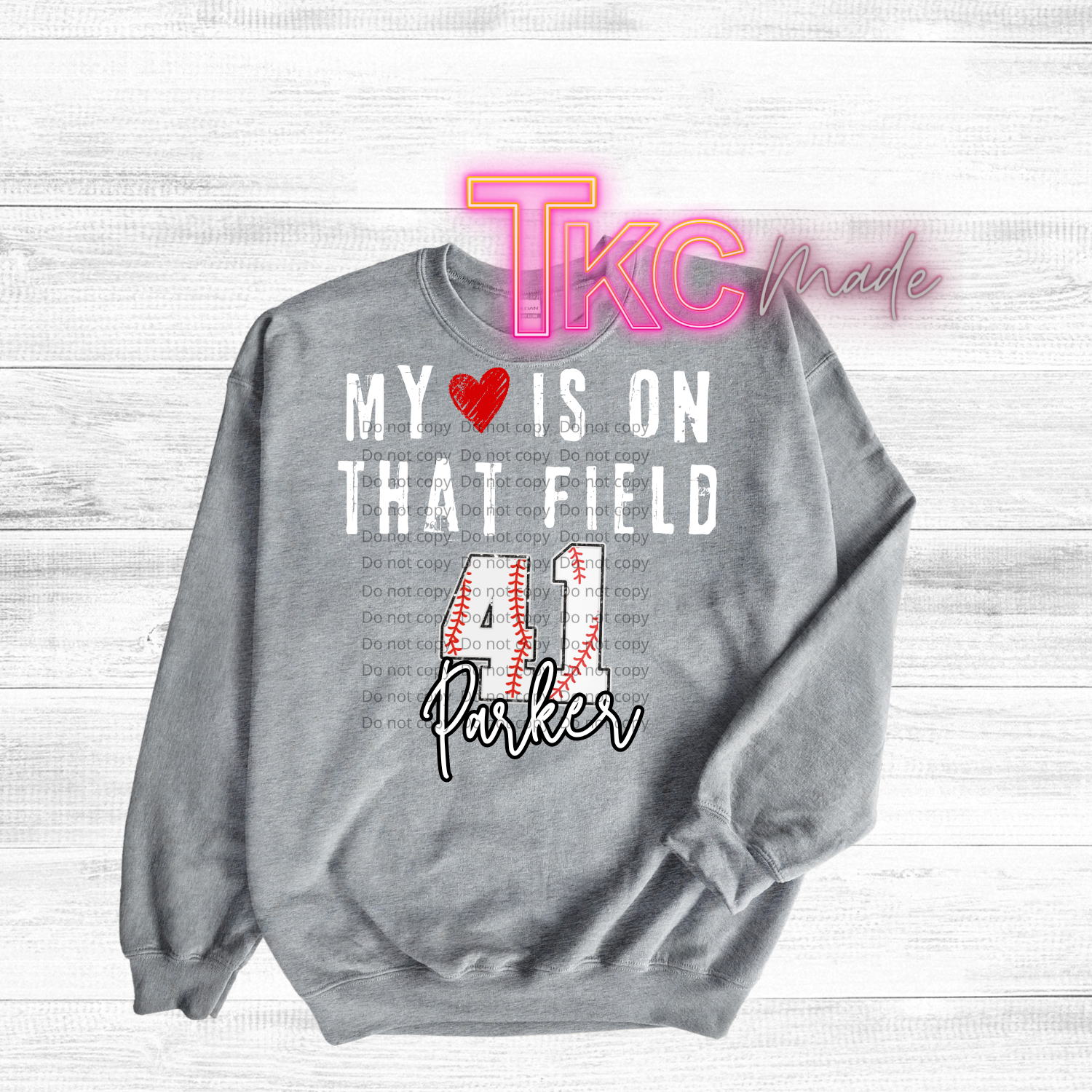 Gray t-shirt with baseball text-my heart is on that field with custom name and baseball number on a wooden surface