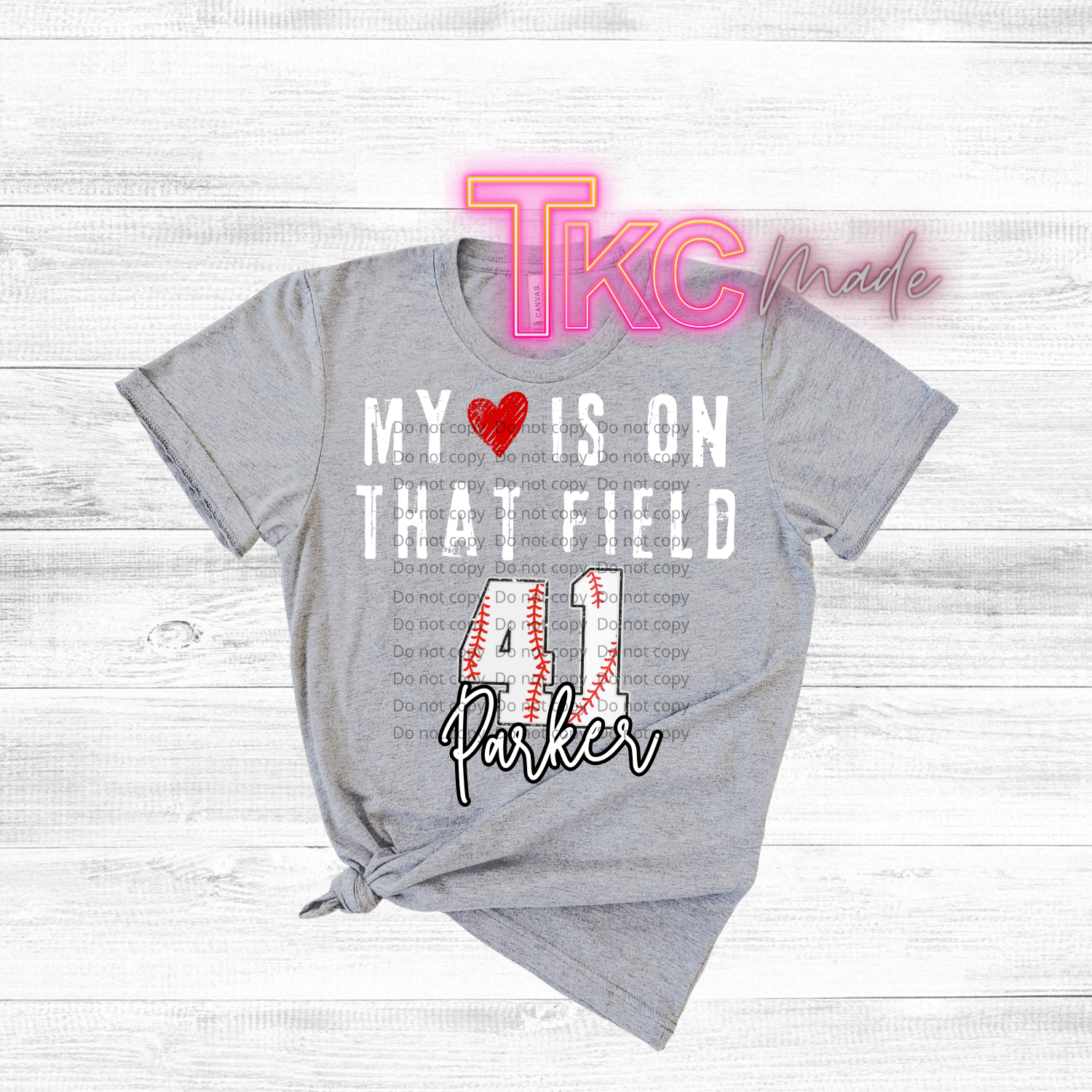 Gray t-shirt with baseball text-my heart is on that field with custom name and baseball number on a wooden surface
