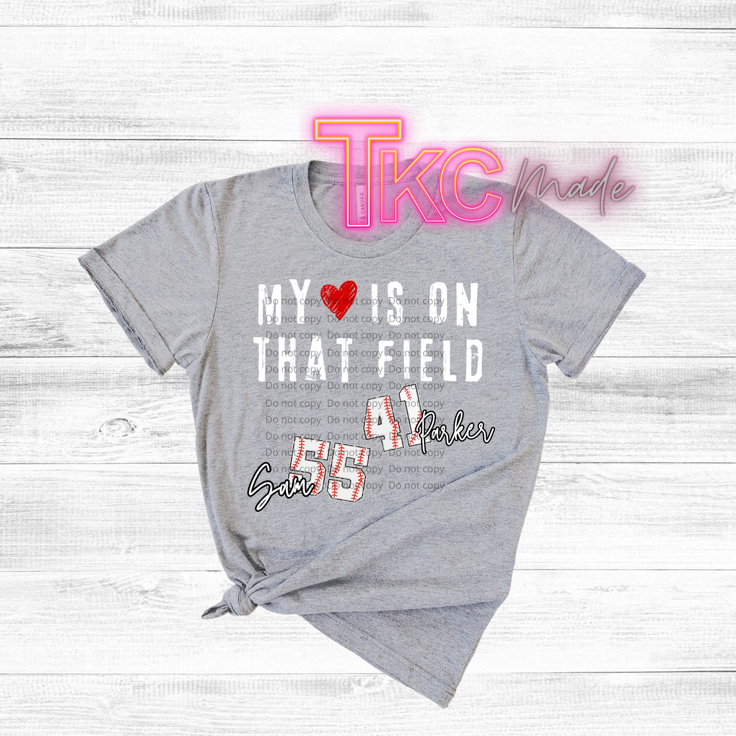 Gray t-shirt with baseball text-my heart is on that field with custom name and baseball number on a wooden surface