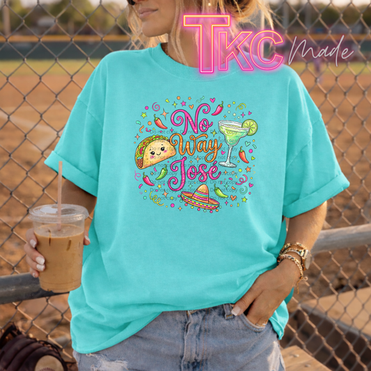 Person wearing a turquoise t-shirt with 'No Way Jose' design, holding a drink, standing in front of a chain-link fence.