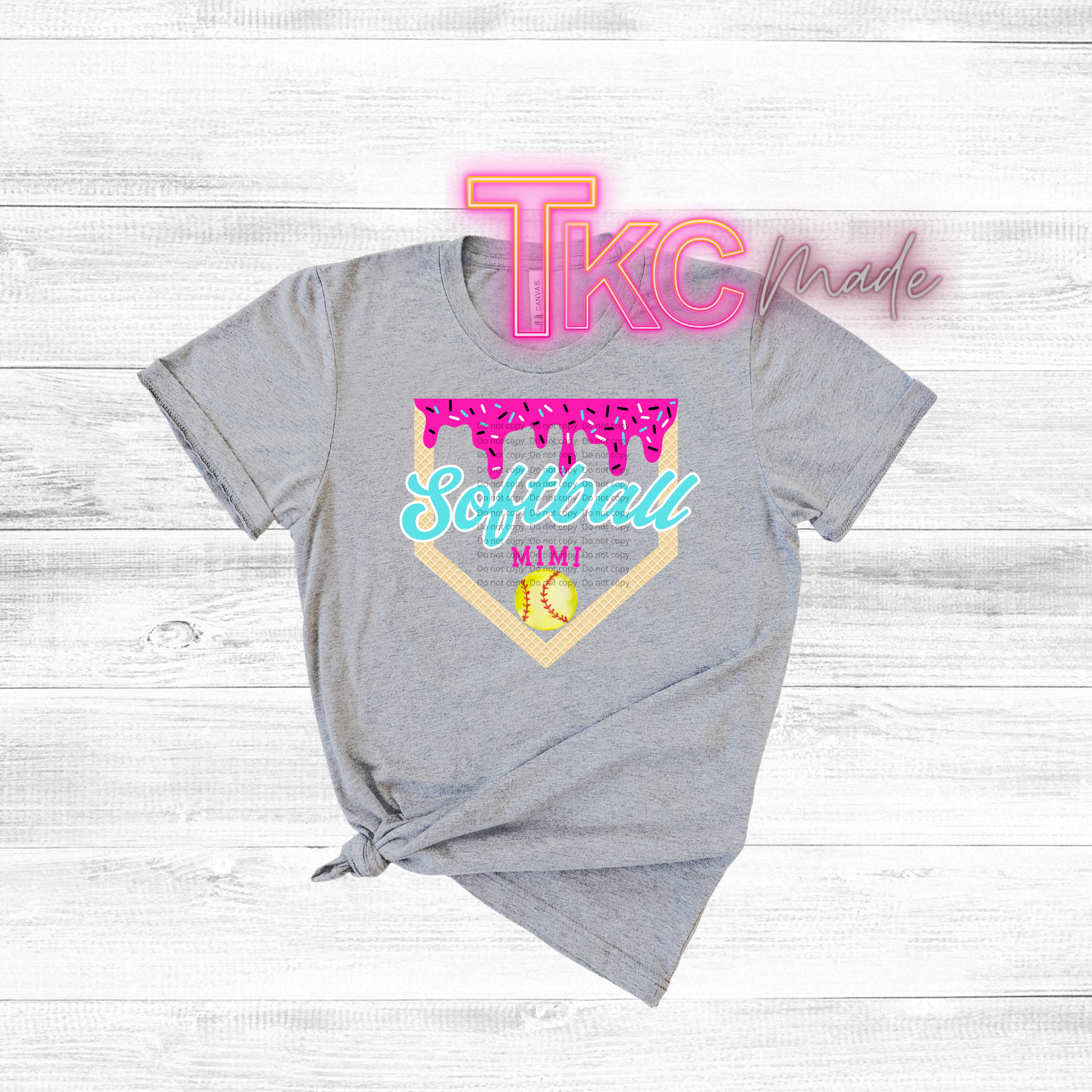 Gray t-shirt with 'TKC made' and 'Softball Mimi' design on a light wooden background