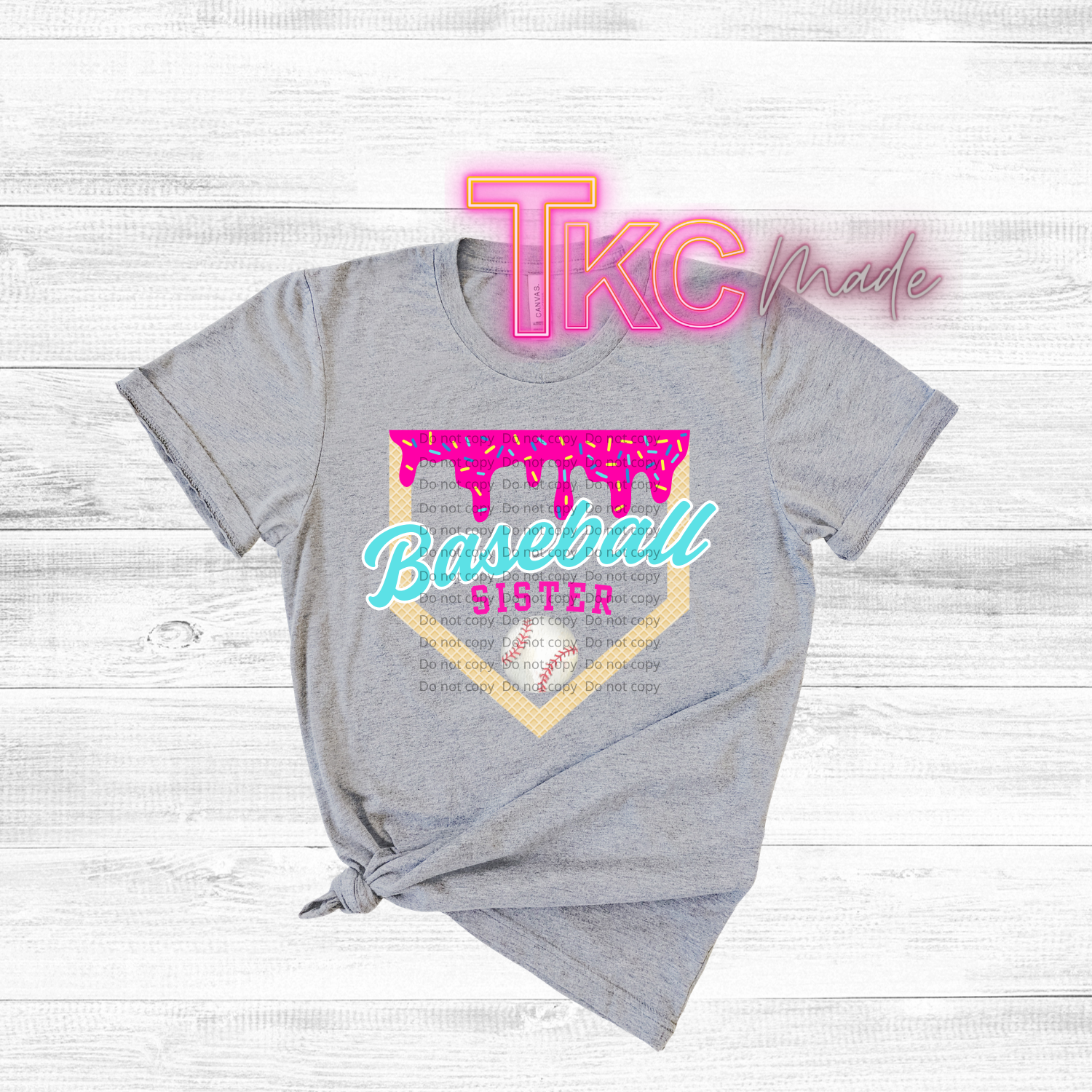 Gray t-shirt with 'Baseball Sister' design and 'TKC made' text on a light wooden background