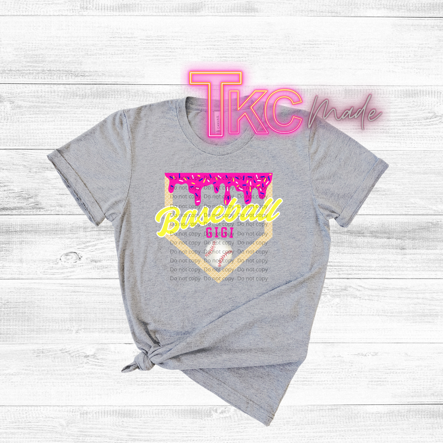 Gray t-shirt with pink and yellow text on a wooden surface