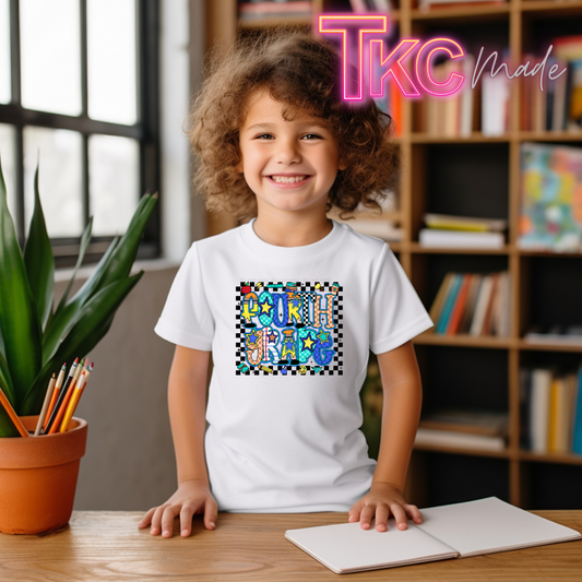 A smiling young girl with curly brown hair sits at a wooden desk wearing a white t-shirt with a colorful graphic that reads 'Fourth grade' on a checkered background. The setting is a cozy room with a bookshelf in the background, a potted plant on the left, and a 'TKC Made' watermark in the top right corner.