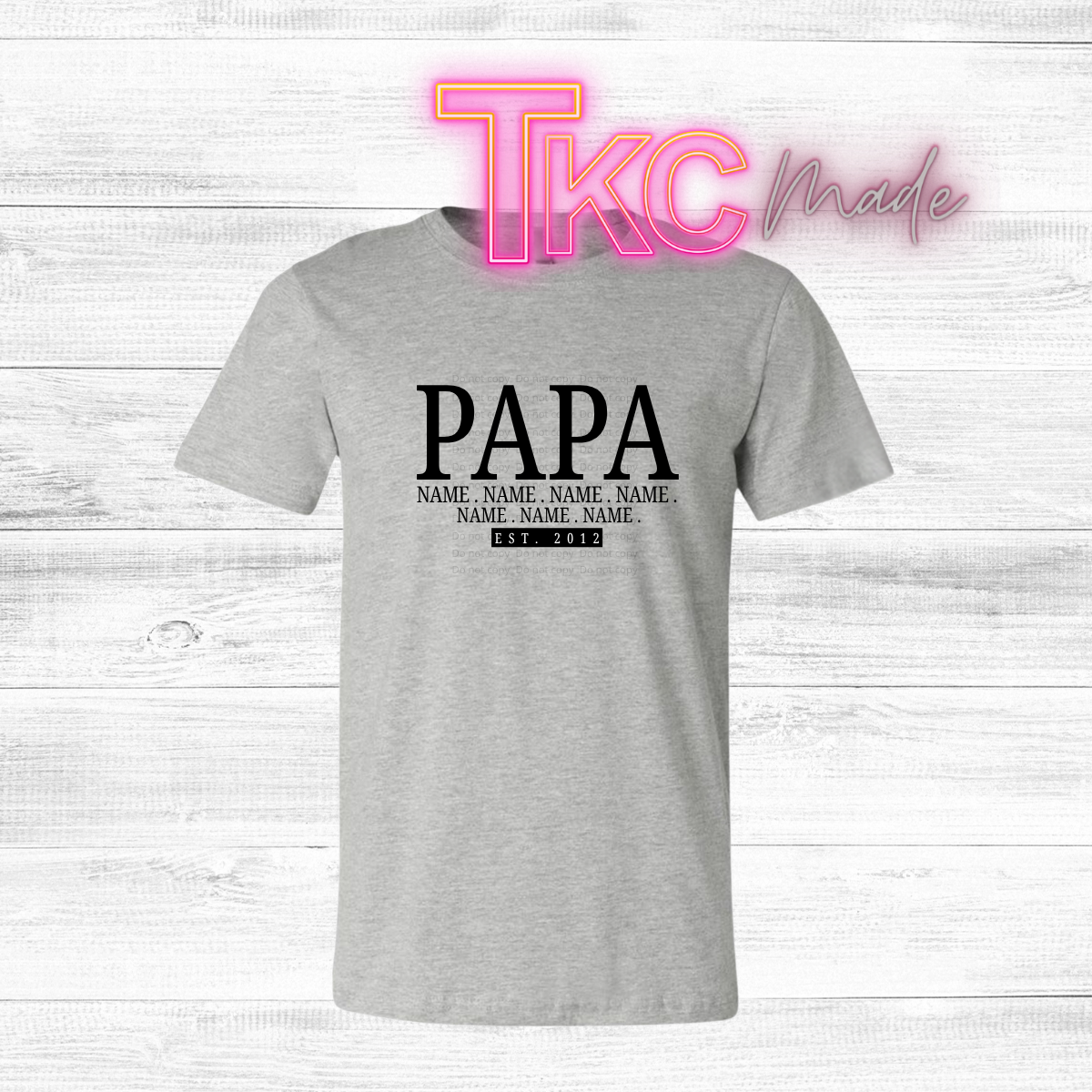 Gray t-shirt with 'PAPA' text  and custom names on a white wooden background