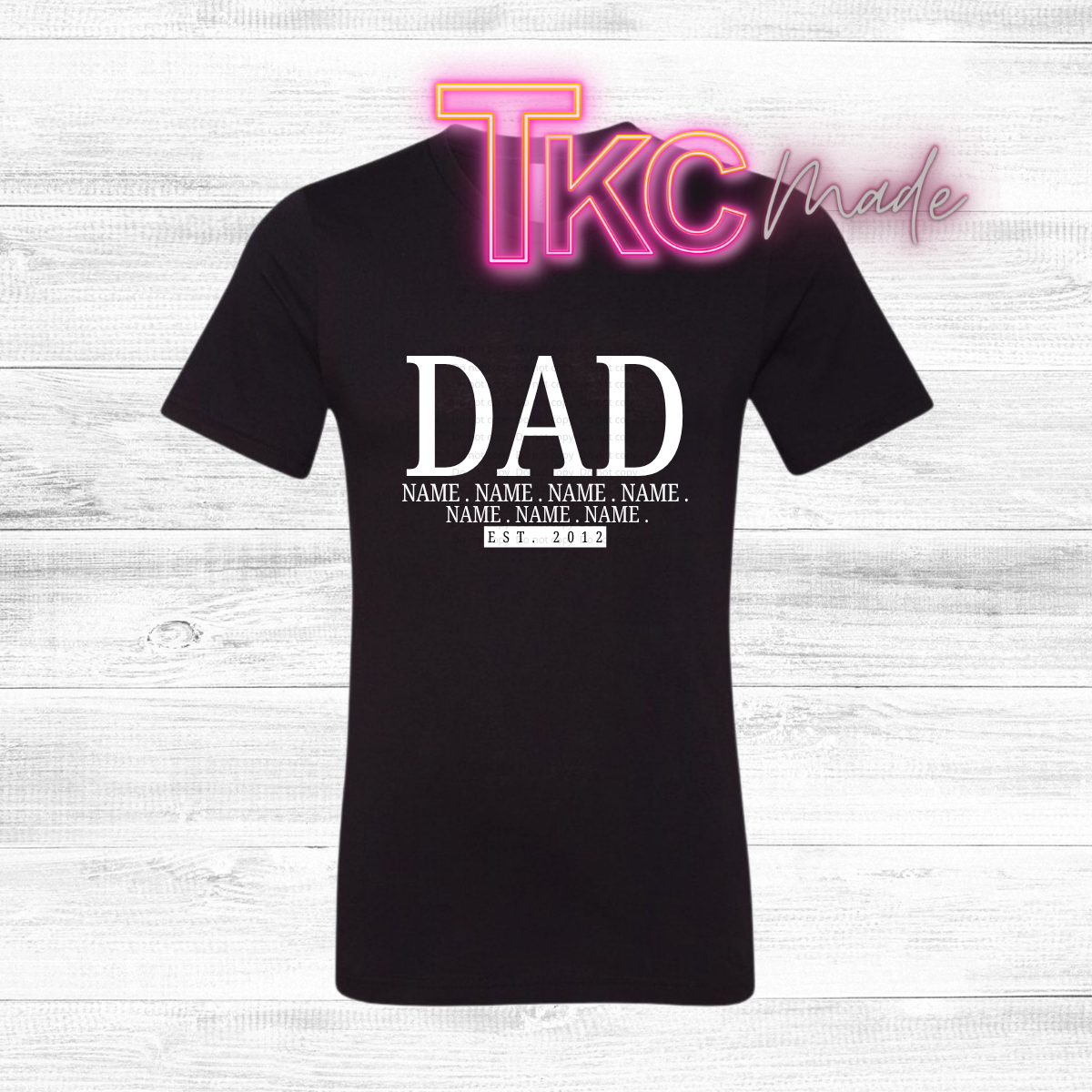 Black t-shirt with 'DAD' with kids names and est year text on a white wooden background