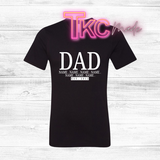 Black t-shirt with 'DAD' with kids names and est year text on a white wooden background