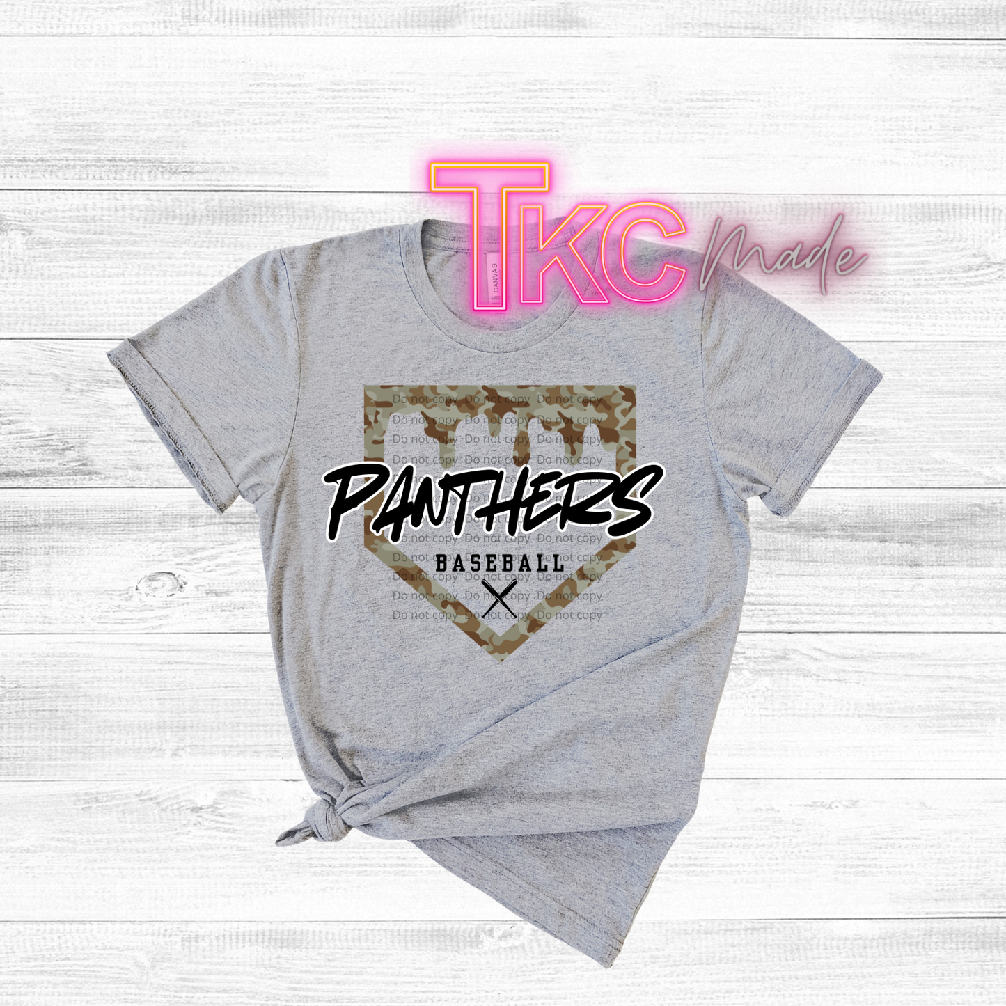 Gray t-shirt with 'Panthers Baseball' design on a wooden surface, featuring the brand 'TKC made'.