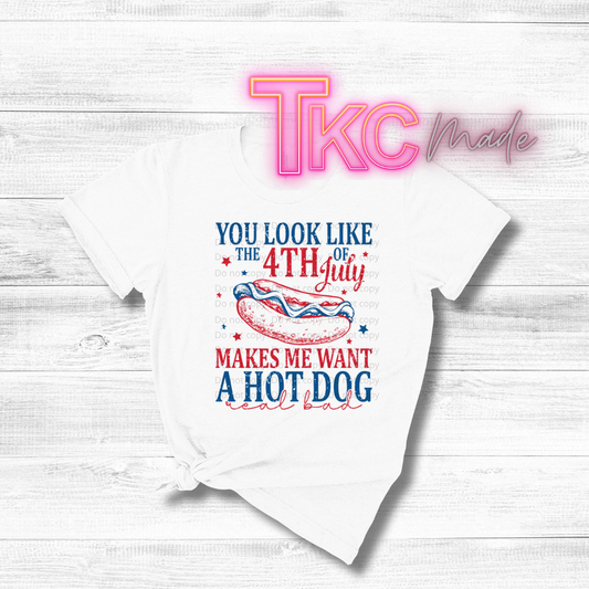 White t-shirt with 4th of July graphic and text on a wooden surface, featuring 'TKC Made' branding.