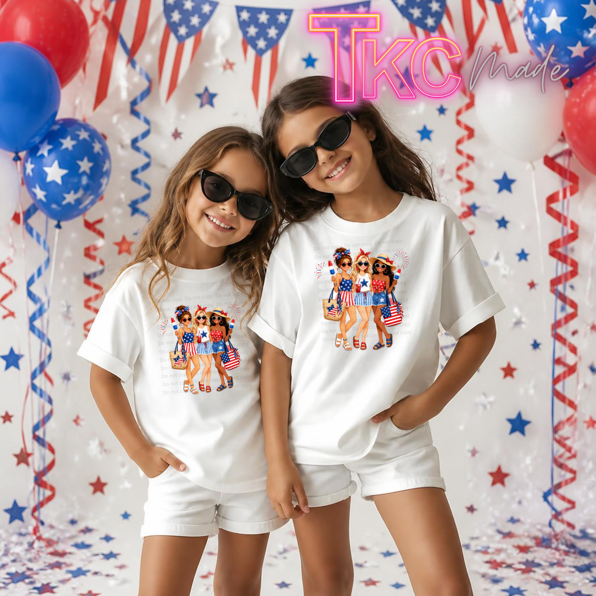 Two children wearing matching white t-shirts with a graphic design in front of a festive background with balloons and streamers.