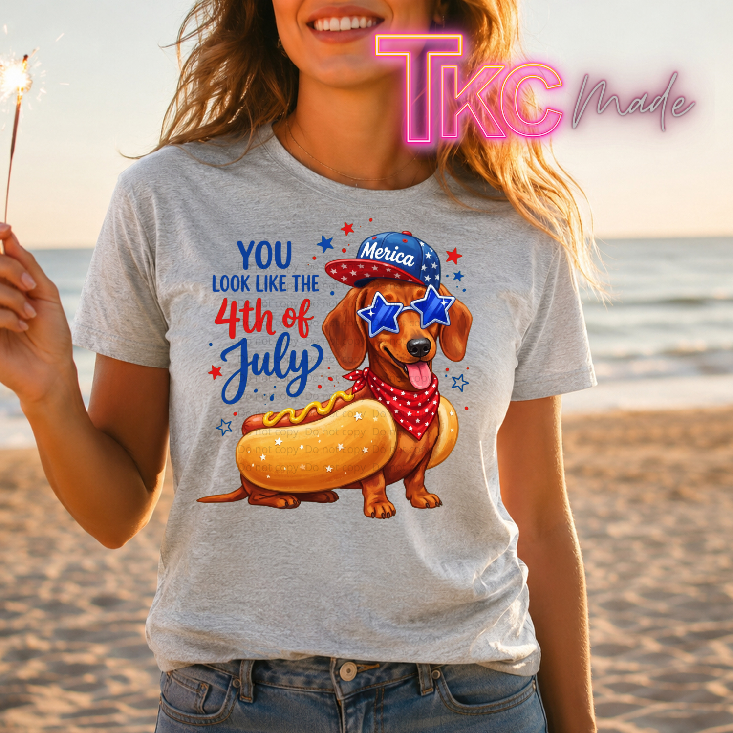 Person wearing a t-shirt with a 4th of July design on a beach