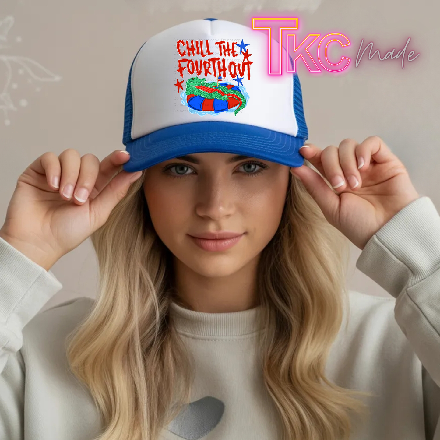 Person wearing a cap with 'Chill the Fourth Out' text and colorful design, holding it up.