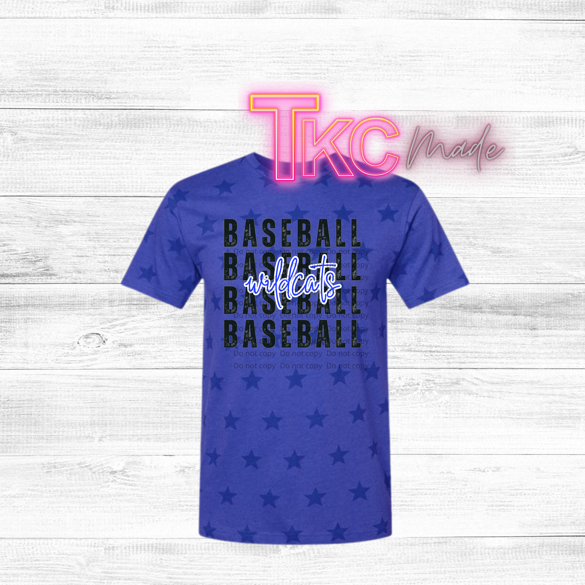 Blue t-shirt with 'BASEBALL WILDCATS' text and star pattern on a white wooden background