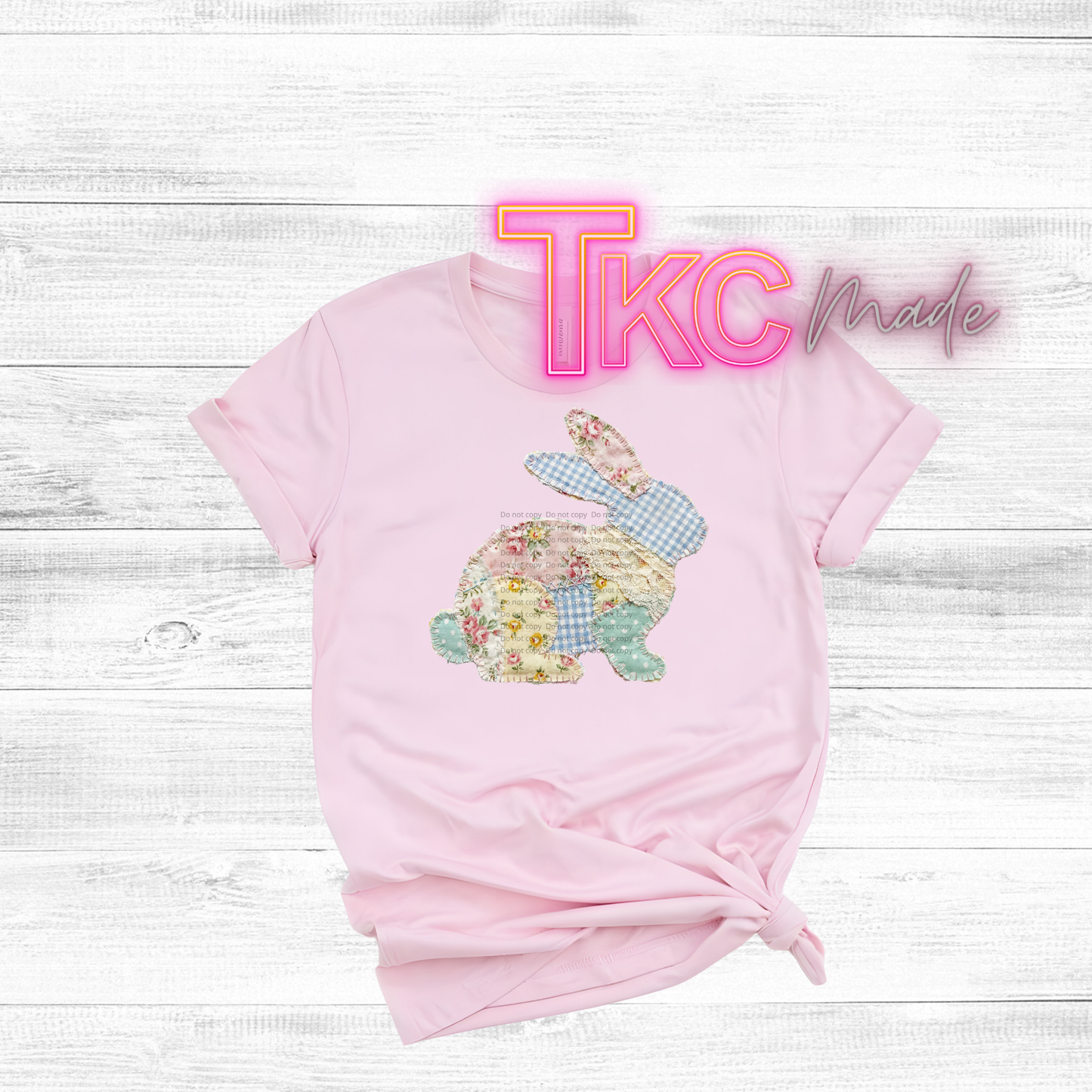 Pink t-shirt with floral bunny patchwork design on a white wooden background, featuring 'TKC Made' text.