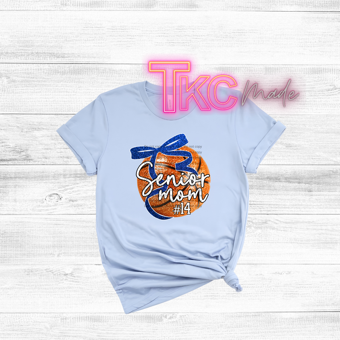 Light blue t-shirt with 'Senior Mom' design on a wooden surface, featuring 'TKC made' branding.