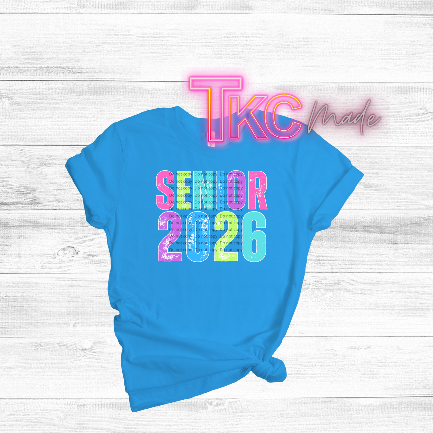 Blue t-shirt with 'Senior 2026' text on a light wooden surface