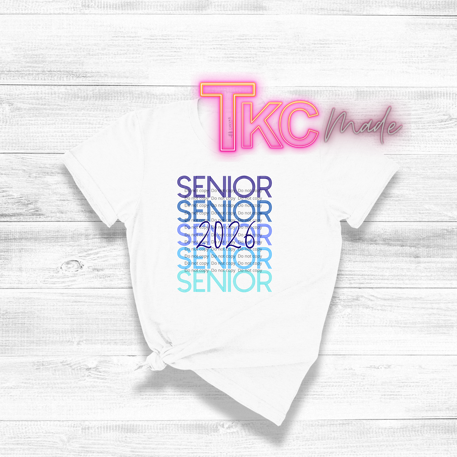 White t-shirt with 'TKC made' and 'Senior 2026' text on a light wooden surface