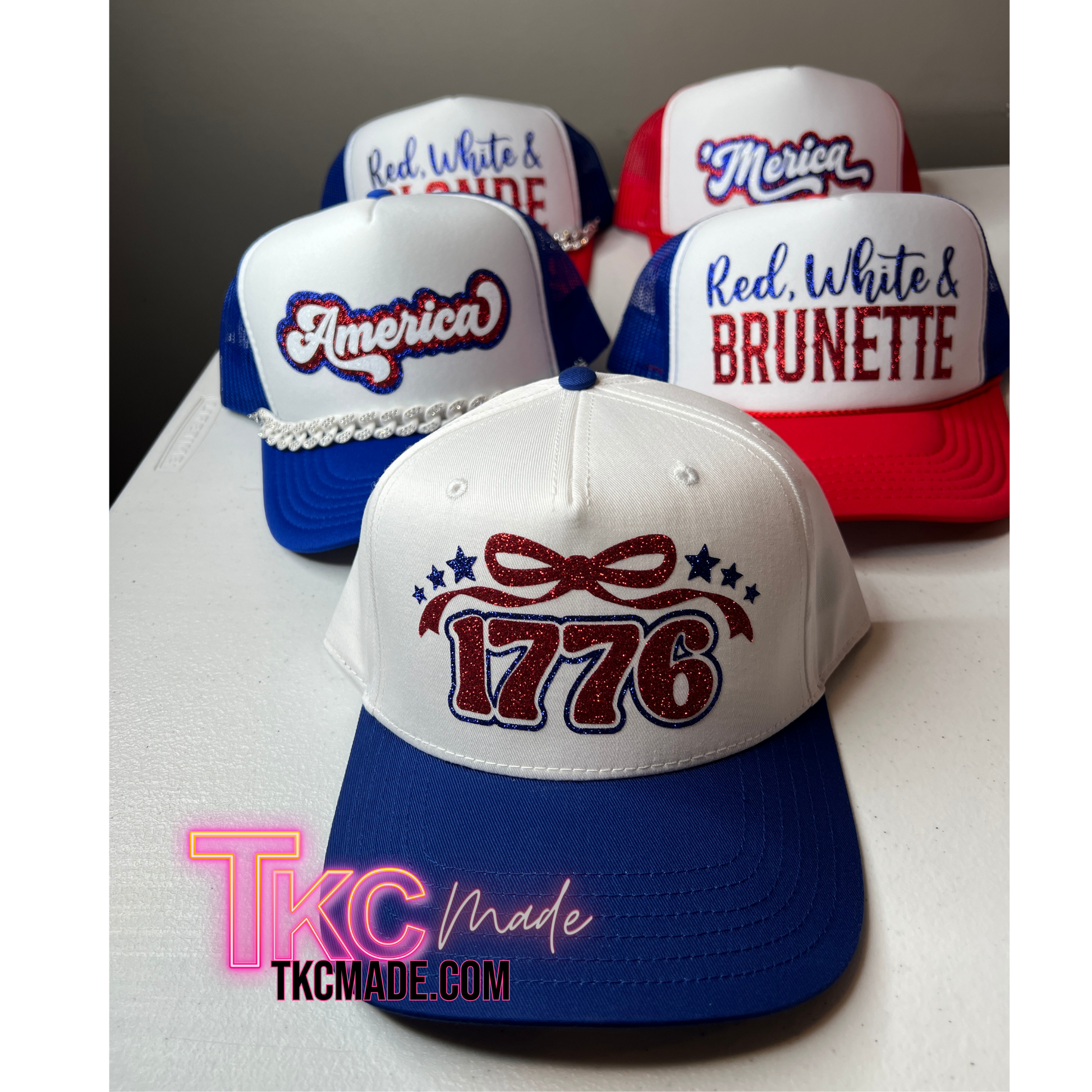 Collection of patriotic-themed baseball caps with text and branding on a white surface.