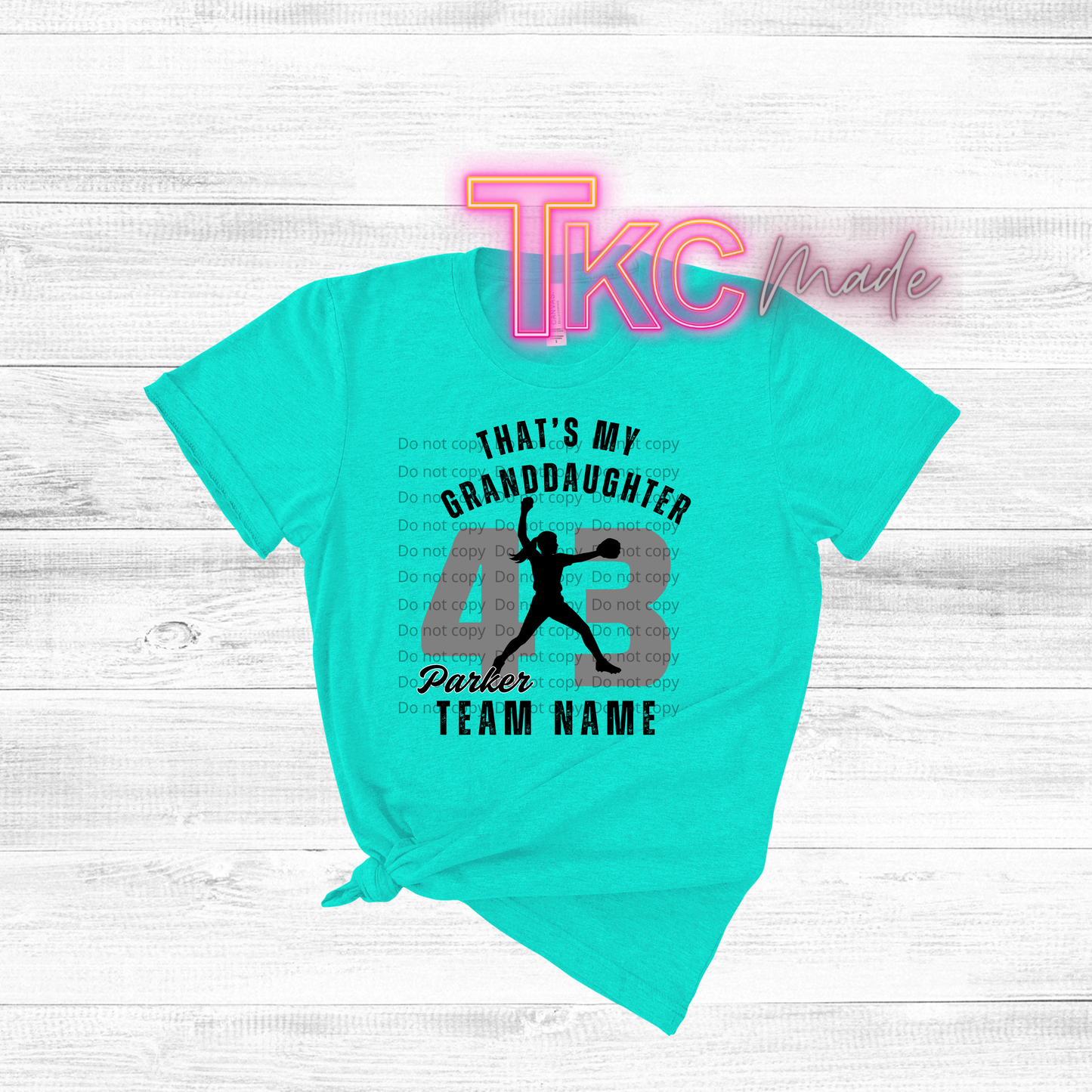 Turquoise t-shirt with personalized sports design on a white wooden background