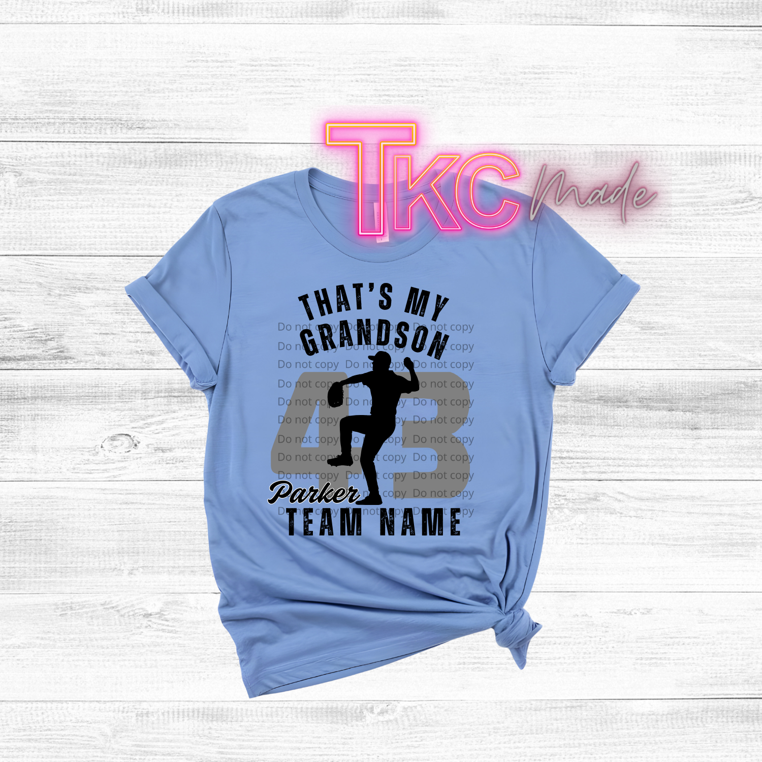 Light blue t-shirt with text and silhouette graphic on a white wooden background