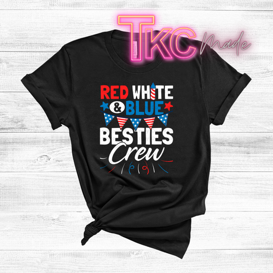 Black t-shirt with 'Red White & Blue Besties Crew' text and American flag design on a light wooden background.