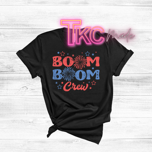 Black t-shirt with 'BOOM BOOM Crew' design and 'TKC made' text on a light wooden background