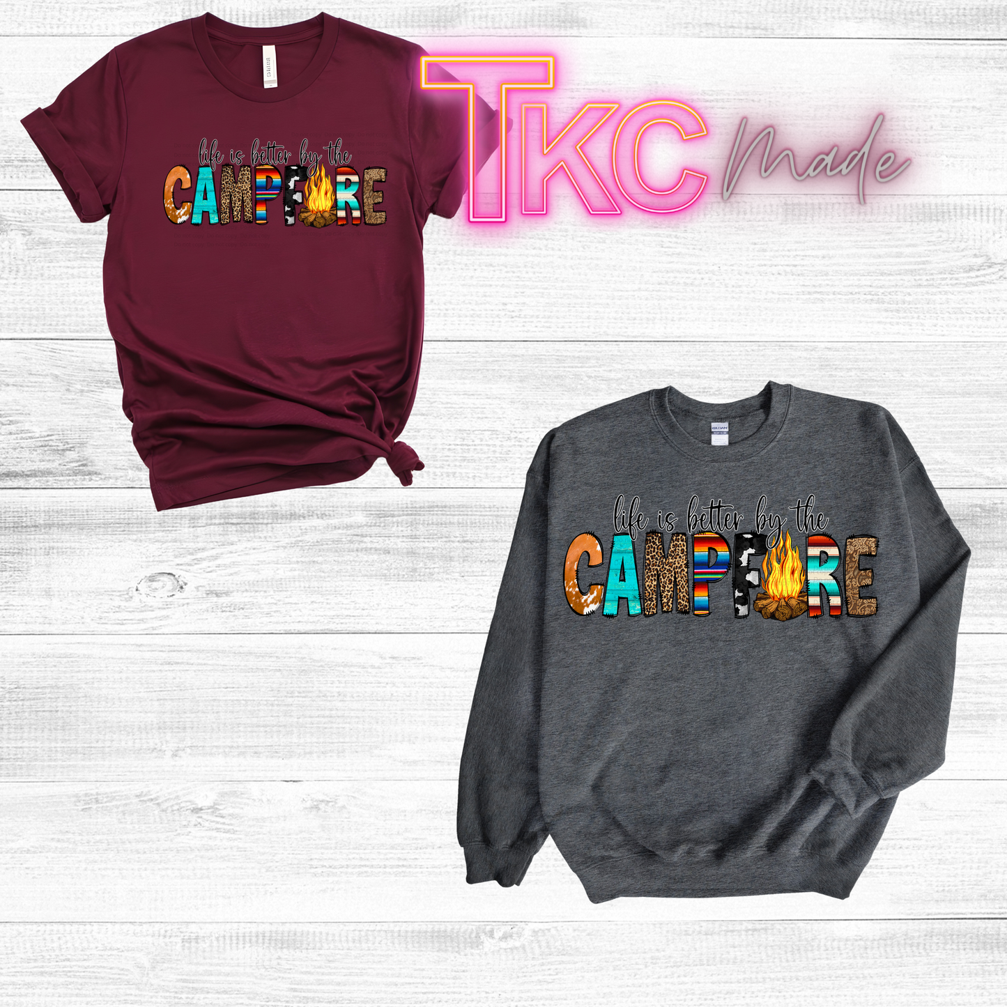 Maroon t-shirt and gray sweatshirt with 'Life is better by the Campfire' text on a light wooden surface.