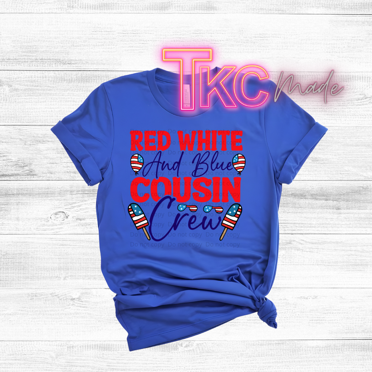 Blue t-shirt with 'Red White and Blue Cousin Crew' text and ice cream graphics on a wooden surface.