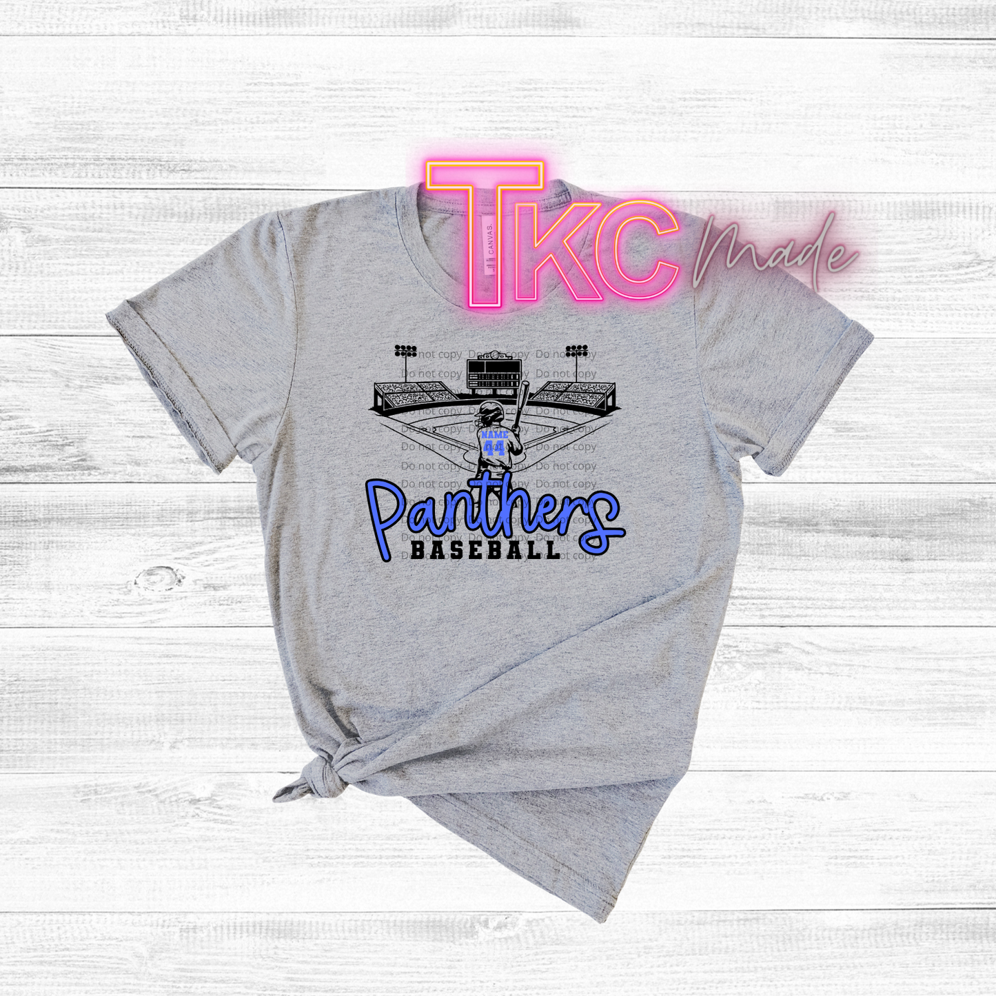 Gray t-shirt with 'Panthers Baseball' design and 'TKC' branding on a light wooden background