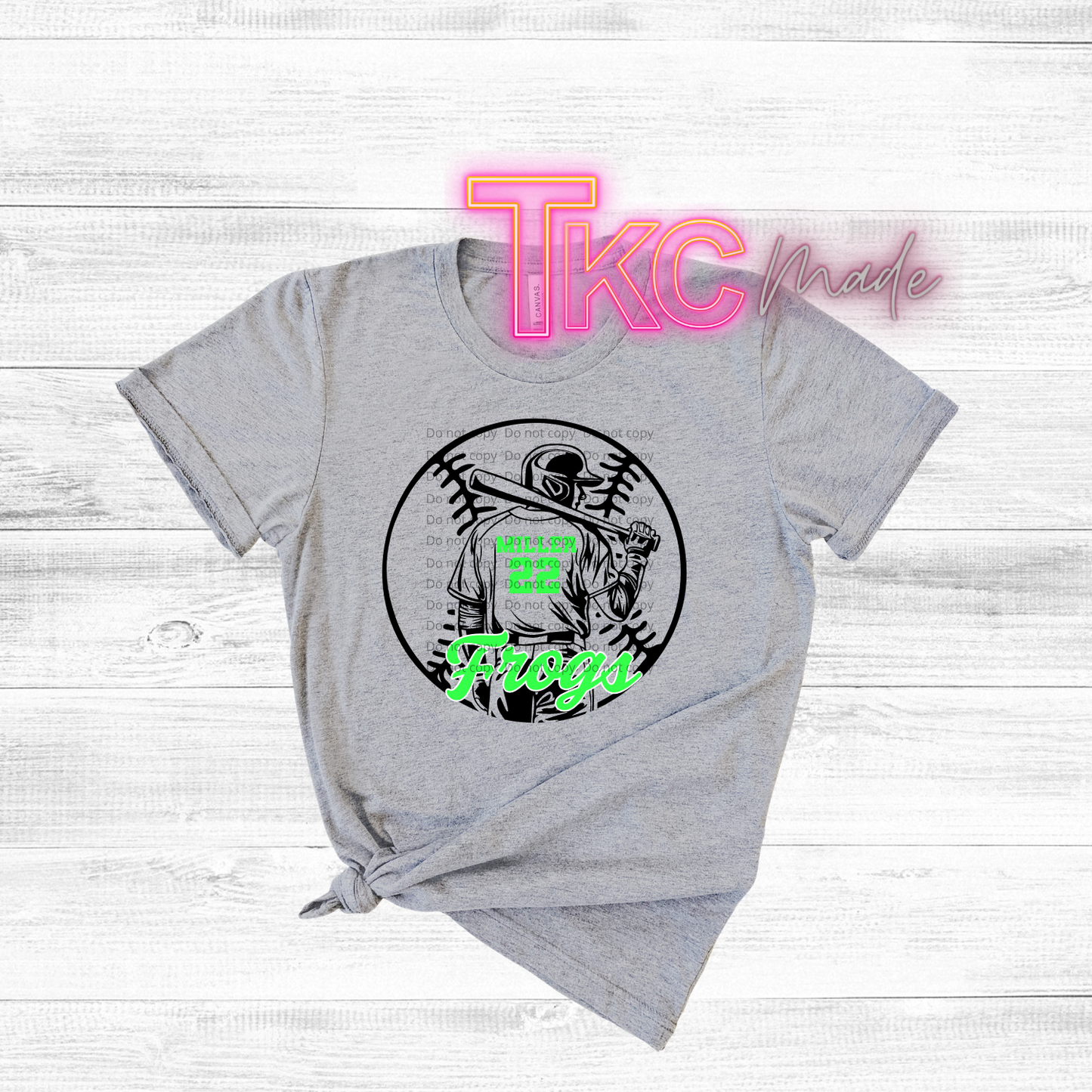 Gray t-shirt with a graphic design and 'TKC made' text on a light wooden background