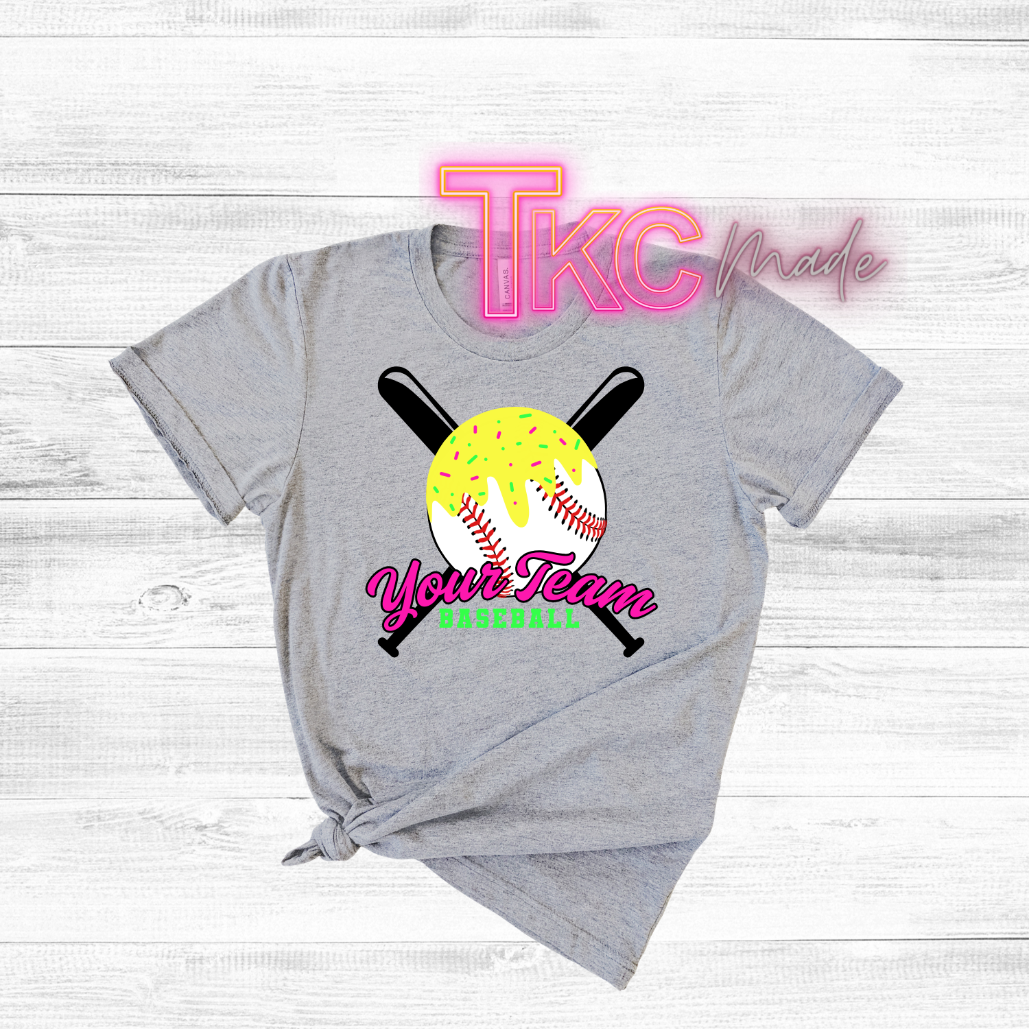 Gray t-shirt with baseball graphic and 'TKC made' text on a wooden surface