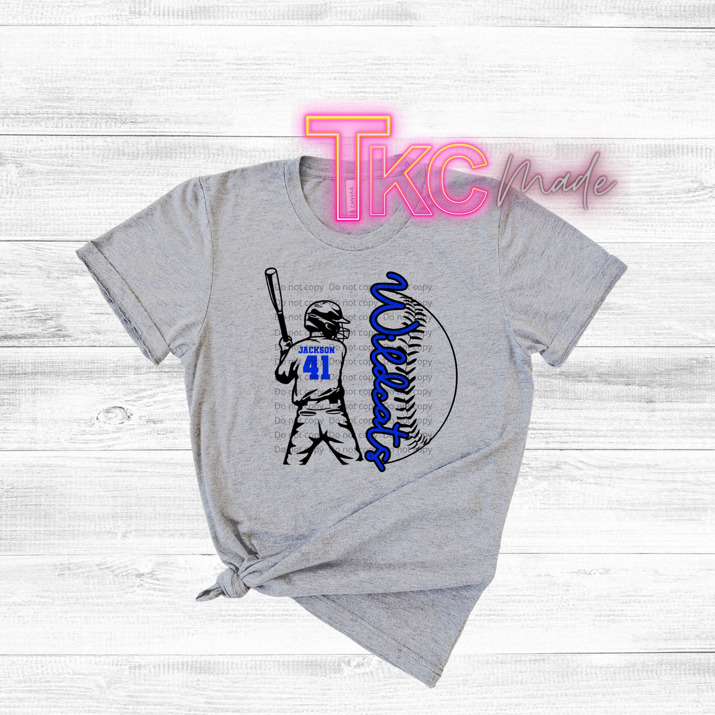 Gray t-shirt with sports-themed design and 'TKC made' text on a light wooden background