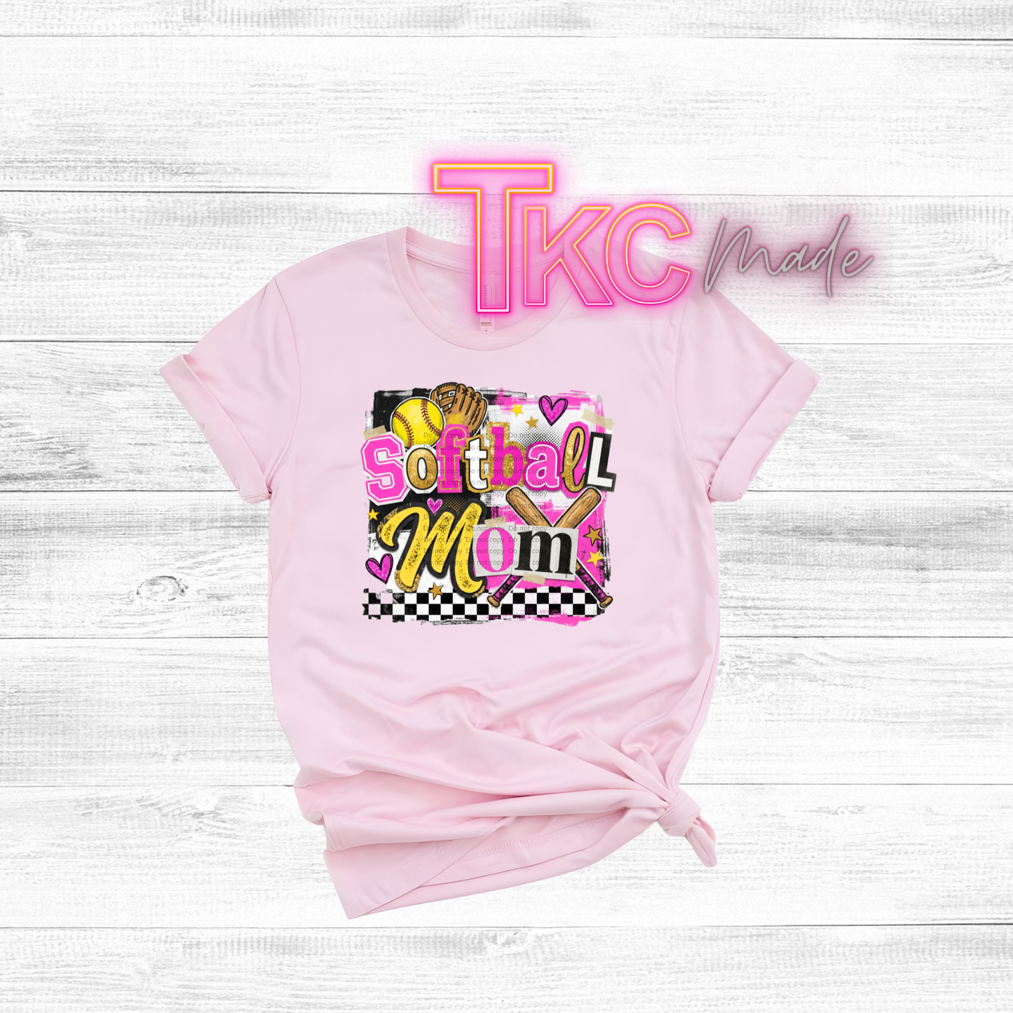 Pink t-shirt with 'So that Mom' text and 'TKC made' branding on a light wooden surface.
