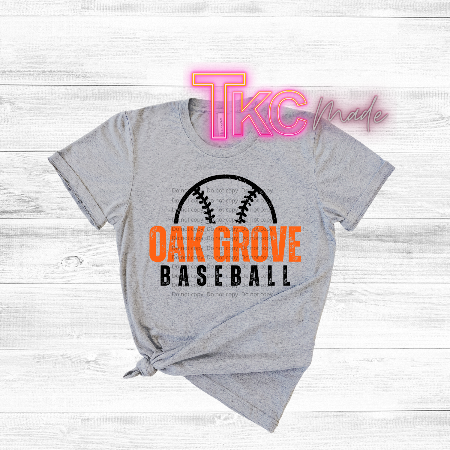 Gray t-shirt with 'Oak Grove Baseball' text and a baseball graphic on a white wooden background.