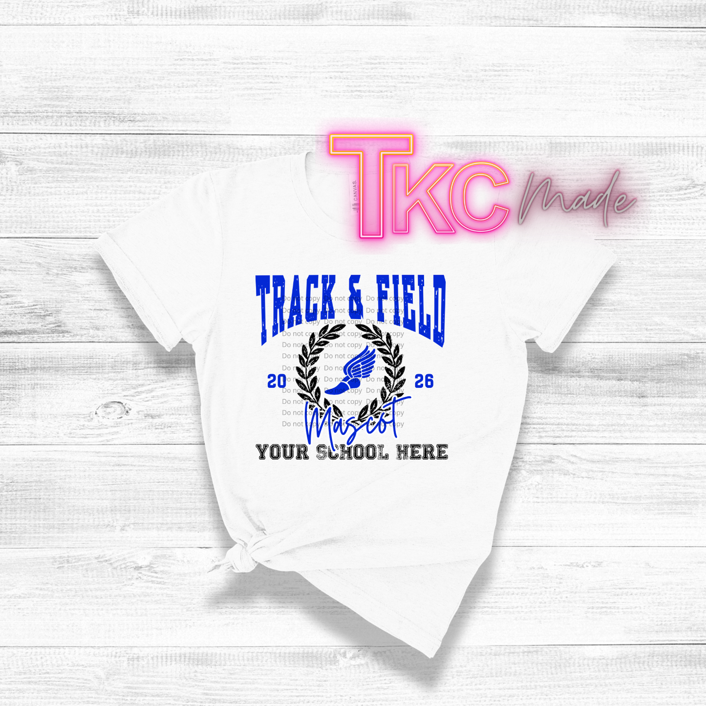 White t-shirt with 'Track & Field' design and 'TKC Made' branding on a light wooden background