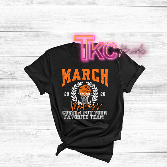 Black t-shirt with basketball design and text on a white wooden background