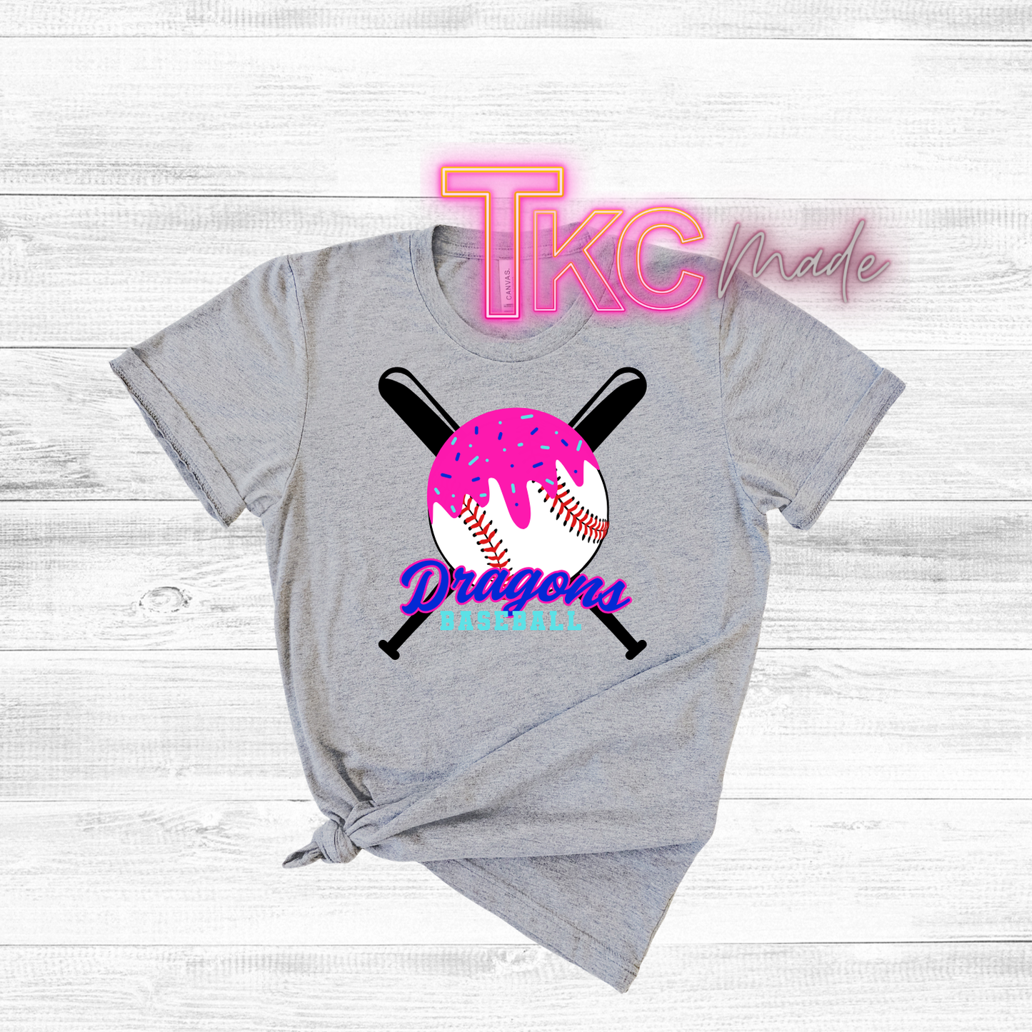 Gray t-shirt with sports-themed design and 'TKC made' text on a light wooden background