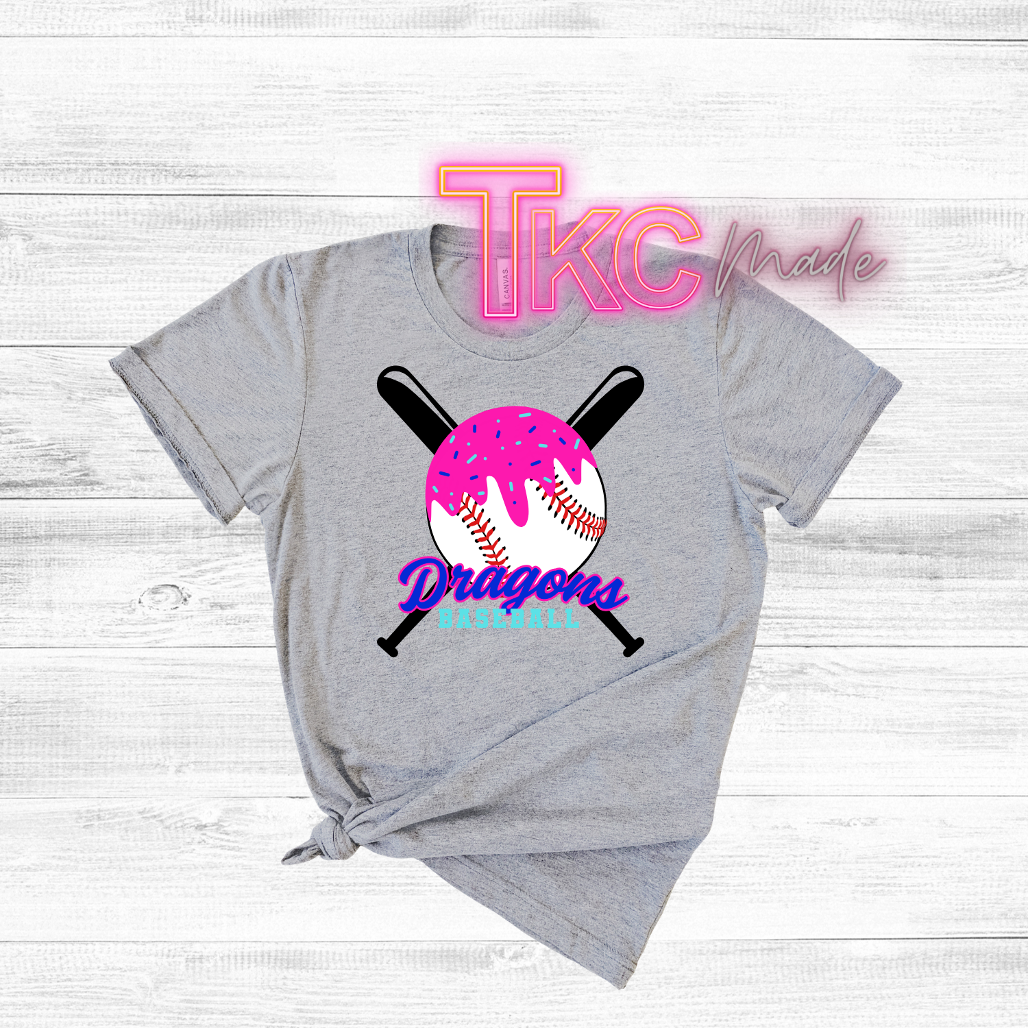 Gray t-shirt with sports-themed design and 'TKC made' text on a light wooden background