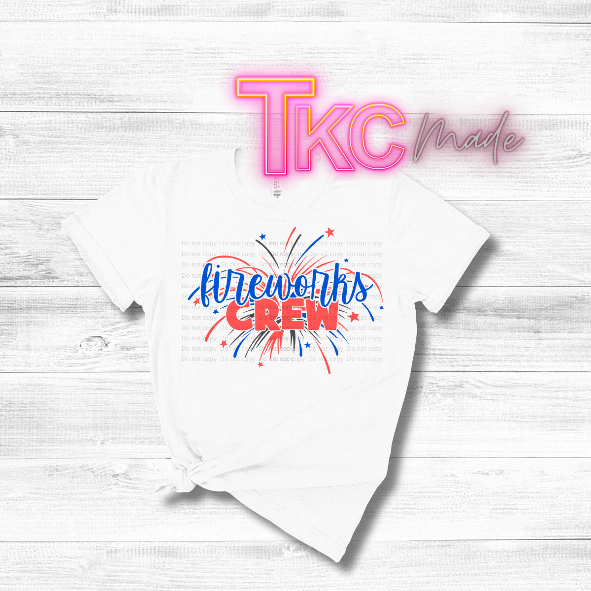 White t-shirt with 'Fireworks Crew' design and 'TKC Made' text on a light wooden background