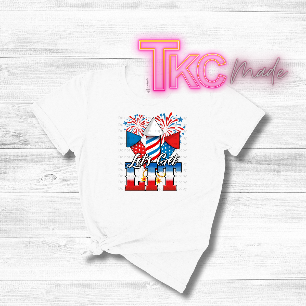 White t-shirt with patriotic design and 'TKC Made' branding on a light wooden background
