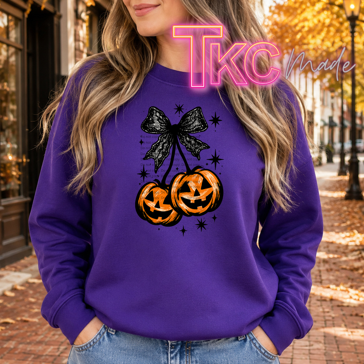 cherry with a jack o lantern pump with a black lace coquette bow on a purple sweatshirt