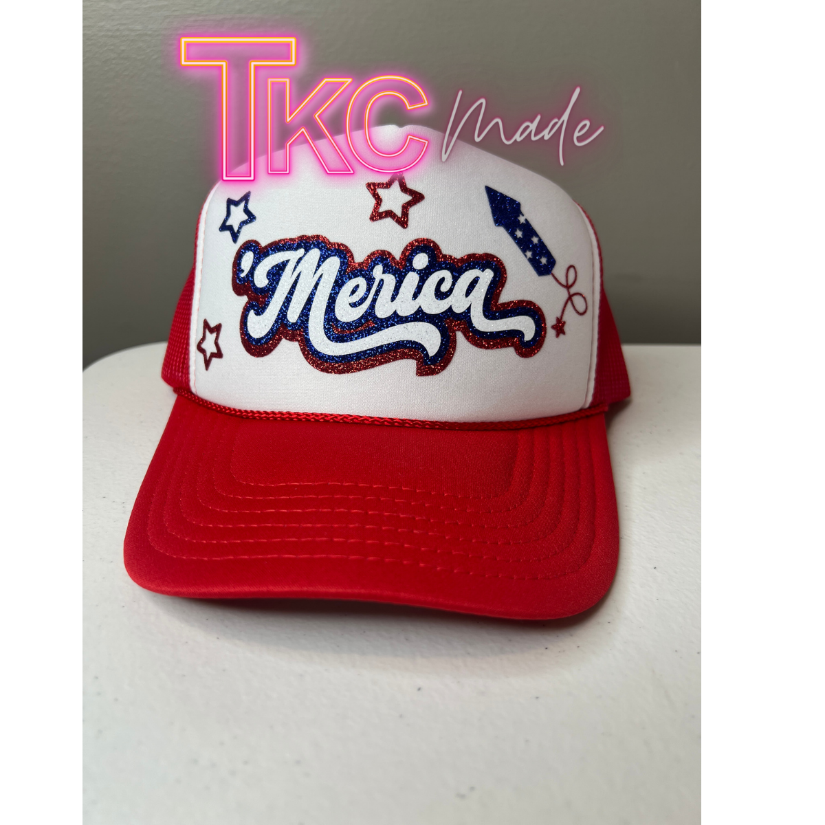 Red and white cap with 'Merica' text on a white surface