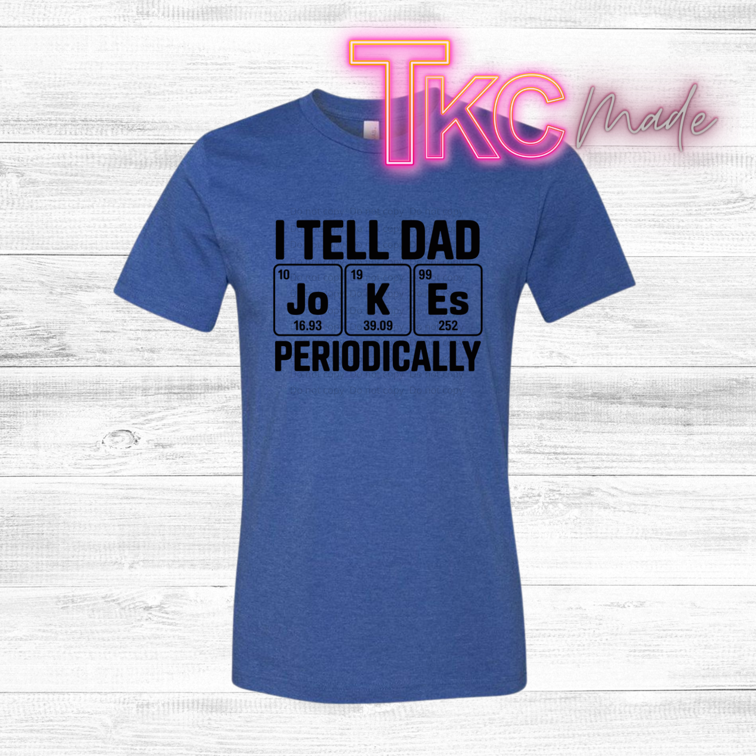 Blue t-shirt with black text  that reads I tell dad jokes periodically on a white wooden background