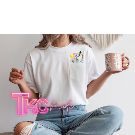 Person wearing a white t-shirt with a floral design and holding a mug, sitting on a couch.