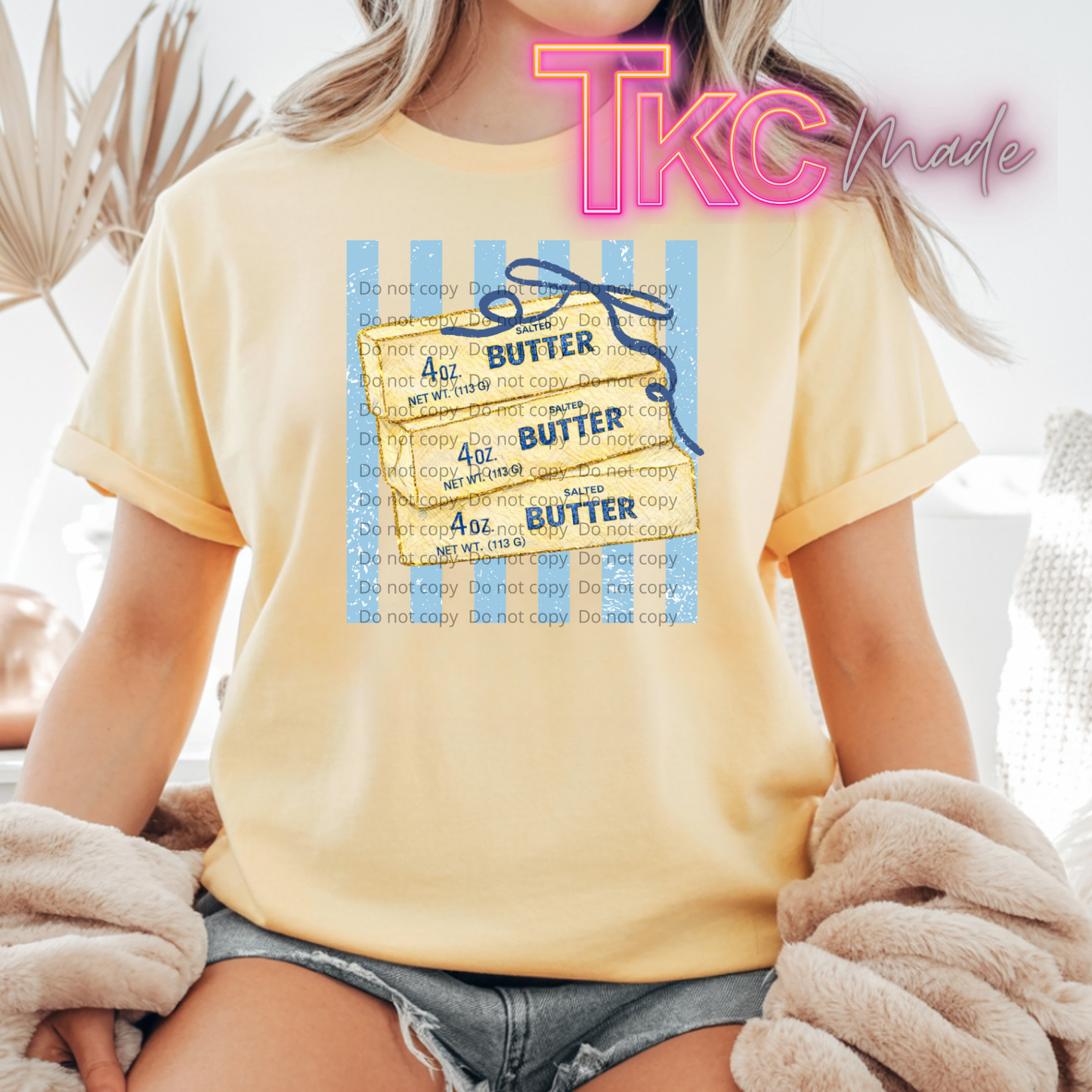 Person wearing a yellow t-shirt with 'Butter' graphic and 'TKC Made' text.