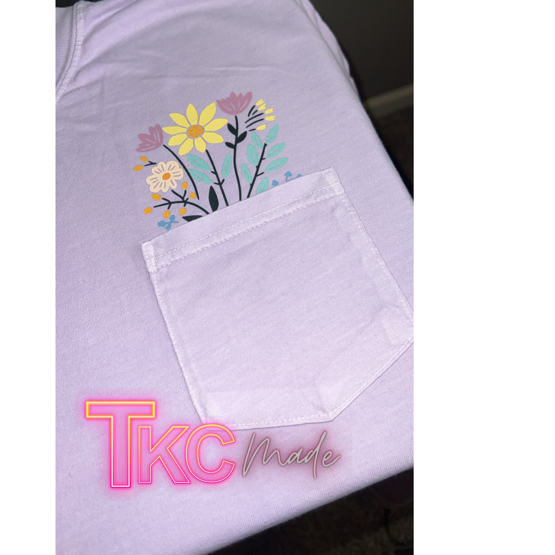 purple tee with floral design coming out of the pocket.