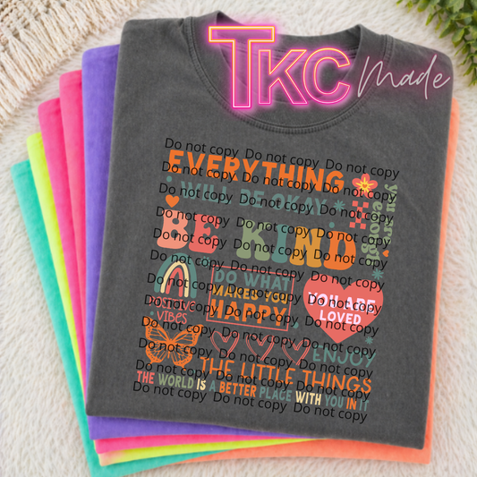 Stack of colorful t-shirts with text and 'TKC Made' branding on a textured surface.